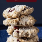 cranberry coconut cookie stacked up with little bits of cranberry showing in the cookies