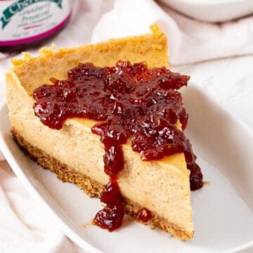 Creamy Pumpkin Vegan Cheesecake Recipe Tofutti with cranberry on top sitting on a plate