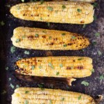 grilled corn half the husk off and butter and fresh herbs drizzled on