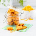 pimento cheese crackers in a glass snap lid jar near a bowl of cheese.