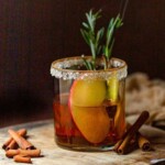 Apple Cider mocktail in glass with slice of apple and spring of smoking rosemary