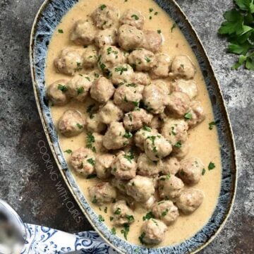 swedish meatballs in a dish with light tan creamy sauce on them