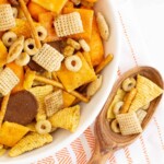 Easy & Unique Slow Cooker Chex Mix Recipe in a bowl with a serving spoon full