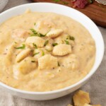 creamy instant pot clam chowder in a bowl with crackers on top