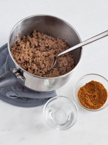 cooked ground beef, taco seasoning and water by pan