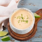 cream orange looking taco bell baja sauce in a small bowl with fresh lime zest on top
