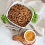 how much taco meat for a crowd in a bowl with taco seasoning next to the bowl.