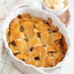Peach cobbler with premade pie crust in an oval baking dish.