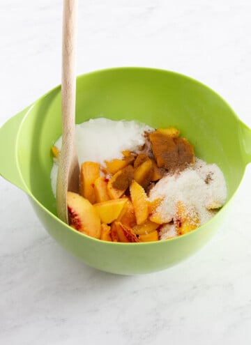 peaches, seasoning, and sugar for peach cobbler in a bowl