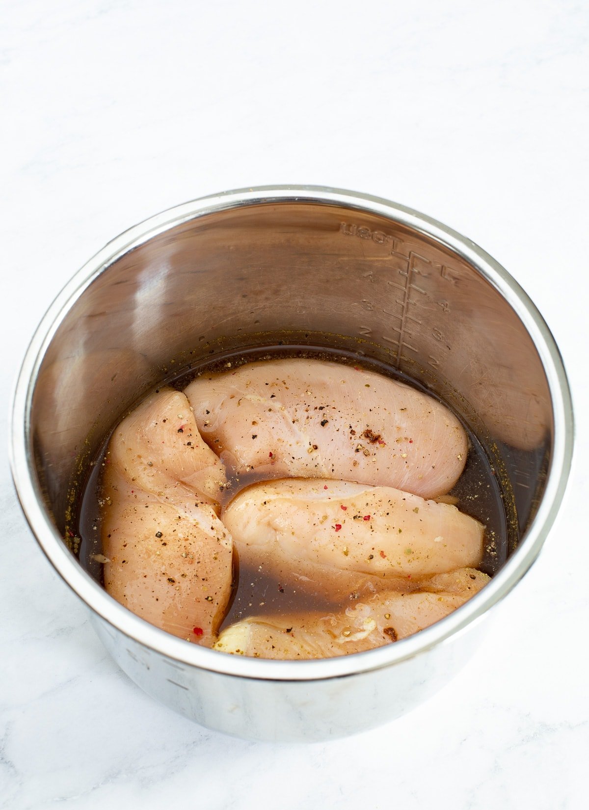 faw chicken breast whole in a instant pot liner. Chicken broth in bottom of pan.