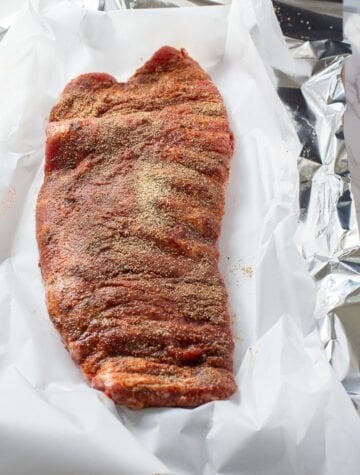 rack of ribs with dry rub on them setting on parchment paper