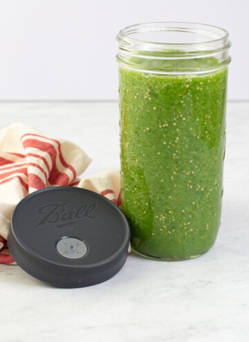 fermented salsa in a ball glass canning jar with ball fermented lid by it