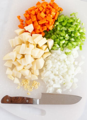 chopped carrots, potatoes, garlic, celery on a cutting board near knife my son gave me for my photos :)