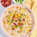 Creamy Crock Pot Chicken Corn Soup with bacon and green onions on top for garnish. Soup has potatoes, carrots, corn, chicken in a white cheesy sauce