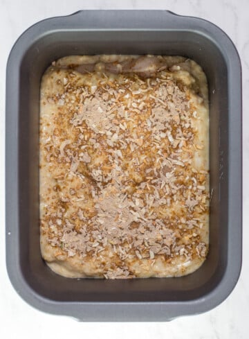 slow cooker pan with french onion soup mixture, chicken in it. Topped with dry french onion soup mix