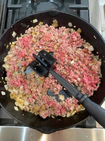 hamburger, onions and garlic in black skillet