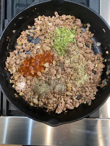 seasonings on top of hamburger in skillet