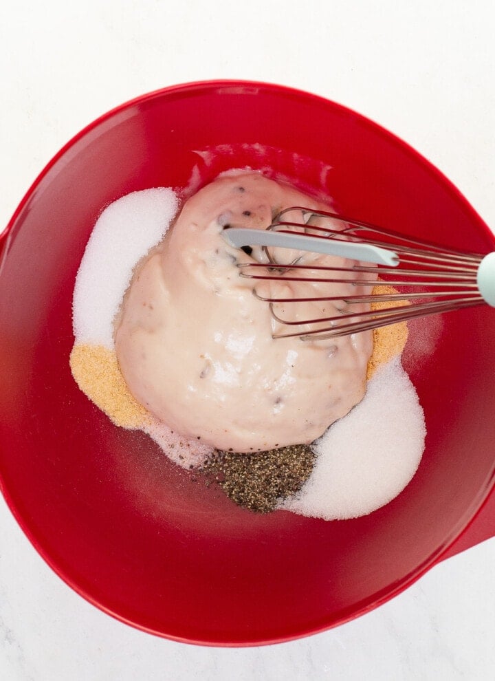 bowl with cream of mushroom soup, pepper, salt, sugar and spices with whisk