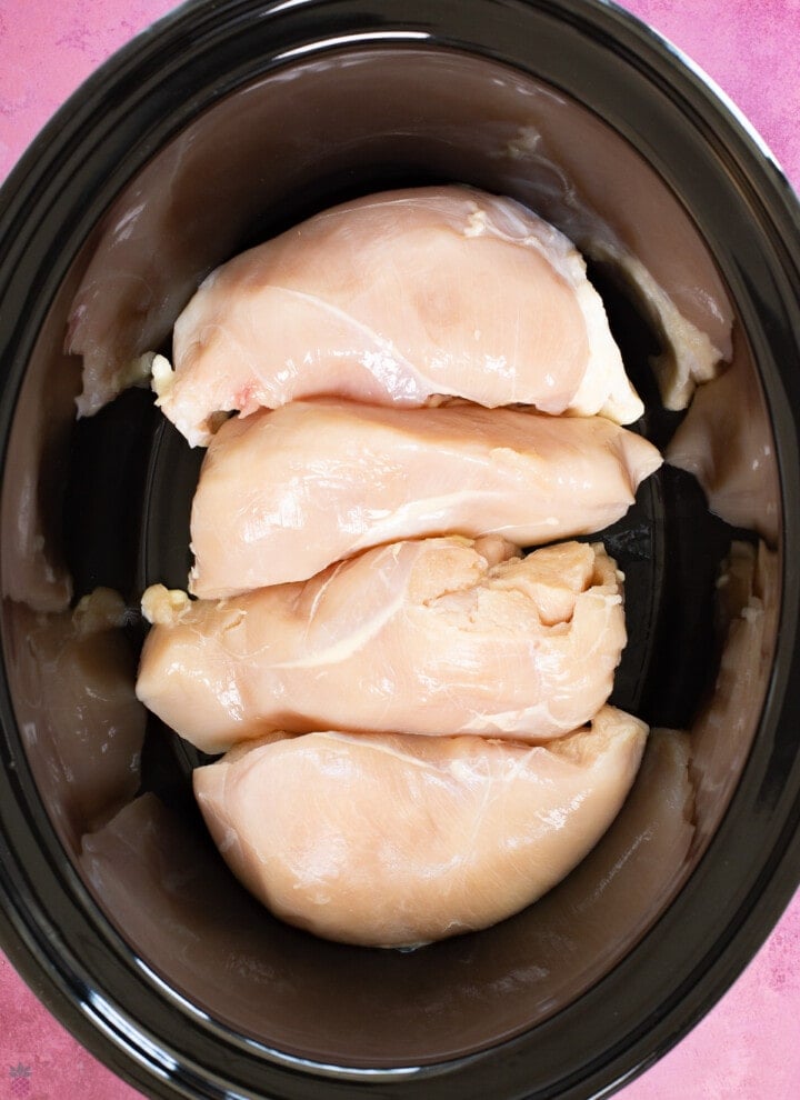 raw chicken breasts in single layer in the slow cooker