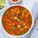 panera 10 vegetable soup recipe in a bowl with limes and hot sauce near it