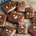 close up of Salted Whiskey Caramels on parchment paper