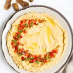 Creamy Boiled Peanut Hummus on plate with peppers on top