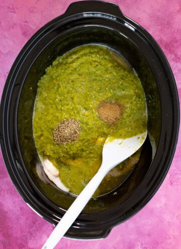 raw chicken and salsa verde in a crock pot bowl
