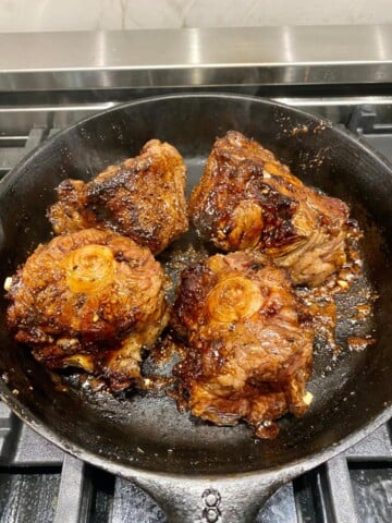braising oxtails in a cast iron skillet