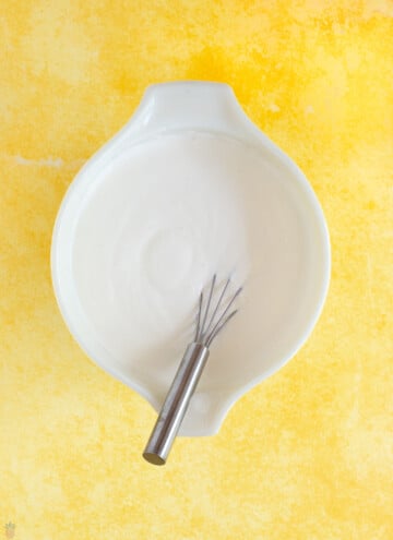 sour cream, baking soda and vanilla in a bowl with whisk