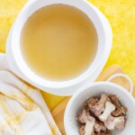 oxtail bone broth in a bowl with bones next to it