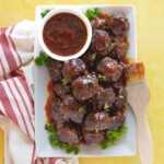 bbq meatballs on plate with bowl of sauce and bbq brush