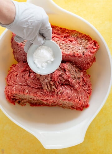 baking soda being sprinkled over ground meat