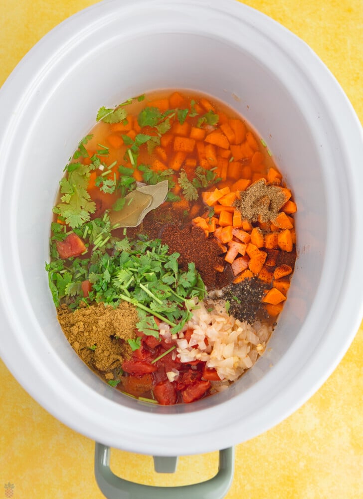 veggies and spices in a crock pot for mexican chicken soup