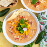 Cheesy tortilla mexican chicken soup recipe in bowls topped with cheese, jalapenos, cilantro and radishes.