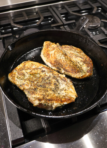 Texas Roadhouse Herb Crusted Chicken being seared in a cast iron skillet
