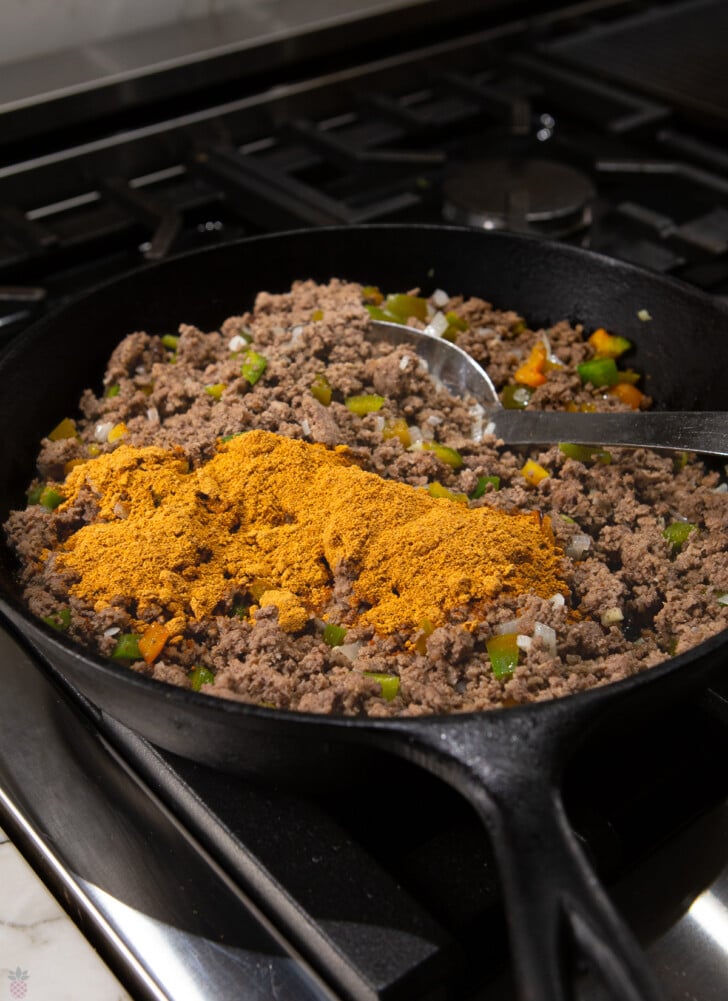 slow cooker mexican casserole ground beef cooked with veggies and seasoning on top