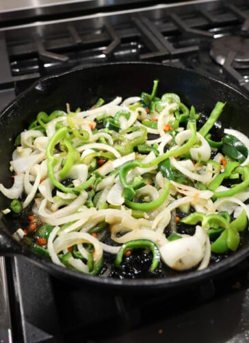cooking peppers and onions in back skillet