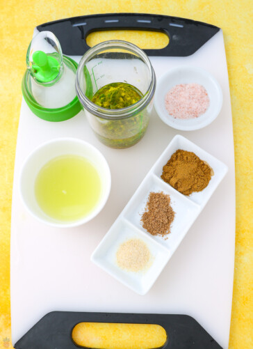 Mexican slaw dressing being prepared jar with oil in it and bowls of lime juice zest salt human coriander and onion salt
