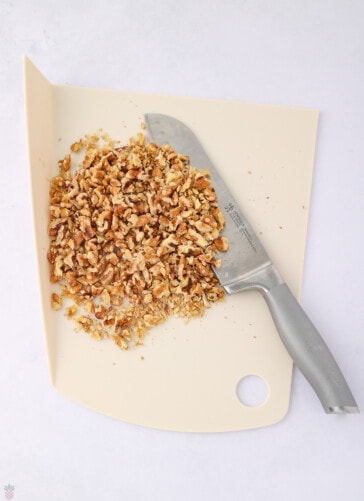 chopped walnuts on a cutting board with knife for butter ball cookies recipe
