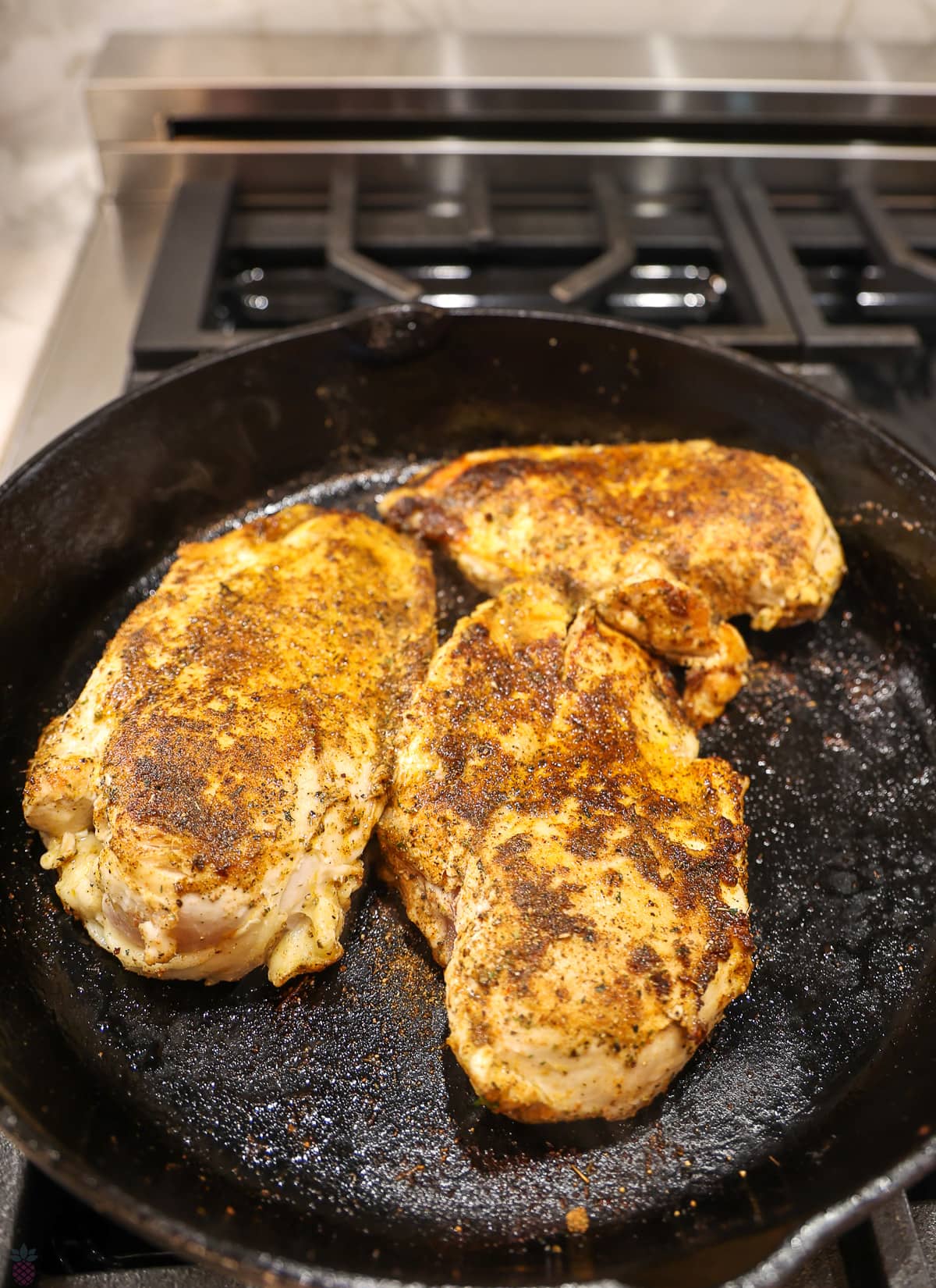Cajun Chicken in cast iron skillet sauteing chicken
