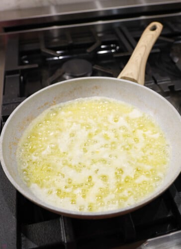 Garlic and olive oil and butter simmering in a pan on the stove