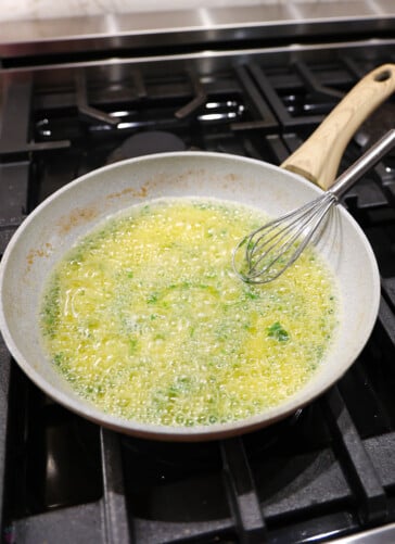 Lemon garlic butter simmering on the stove after parsley has been added