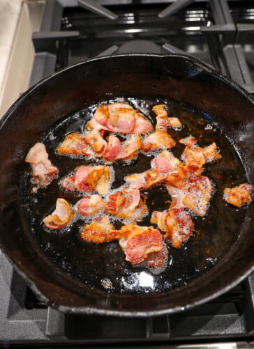bacon cooking in a black skillet
