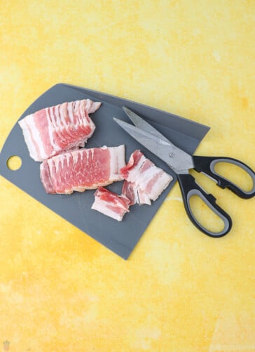 bacon on a cutting board with scissors