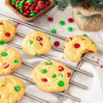 cake mix cookies baked on a cooking tray with a bite out and Christmas m&Ms mixed in the cookie
