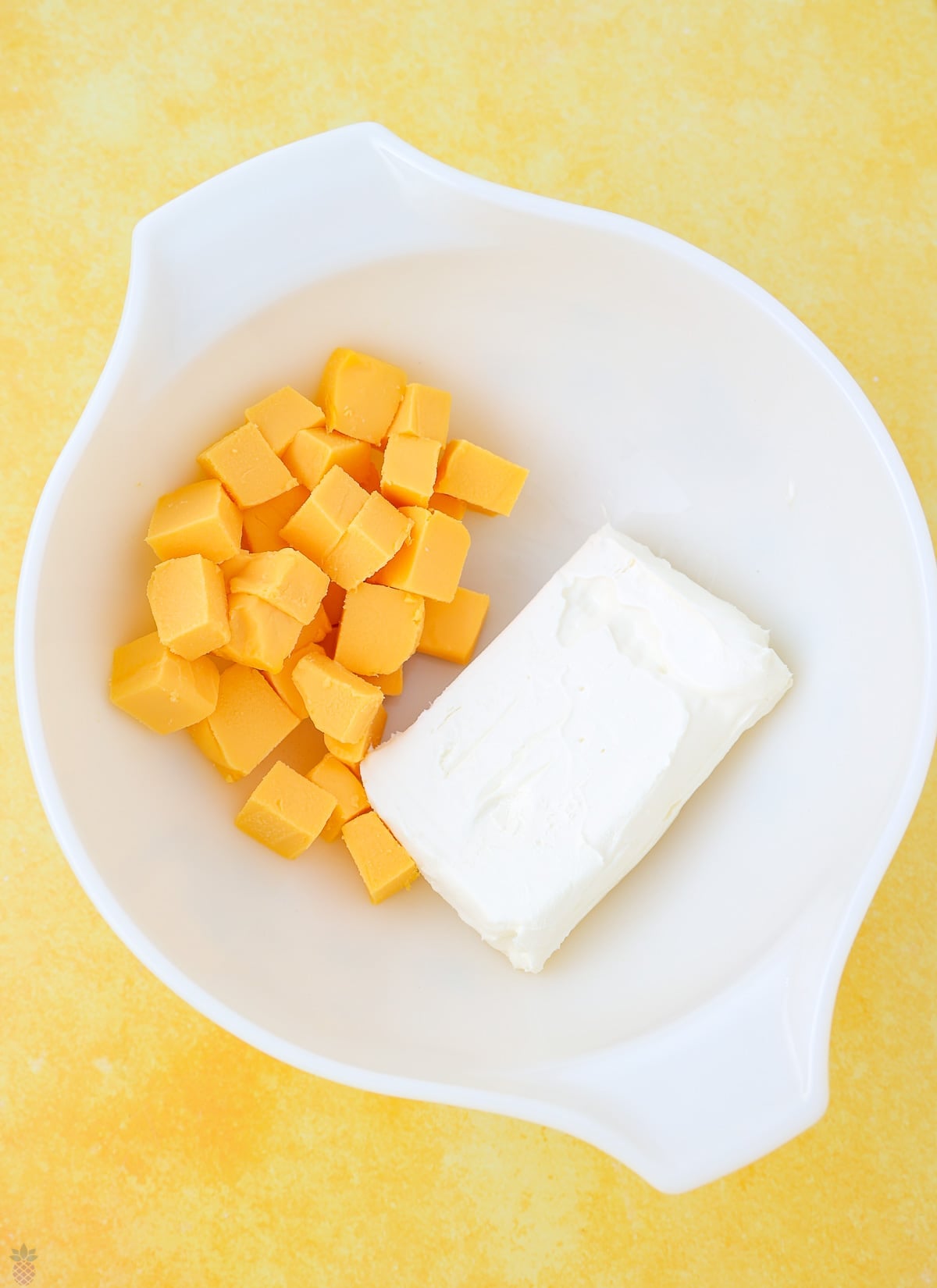 Velveeta and cream cheese in a bowl softening to room temperature