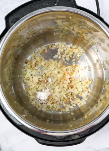 The inside of an instant pot after sauteing onions and garlic