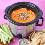 buffalo chicken dip in a crock pot topped with blue cheese