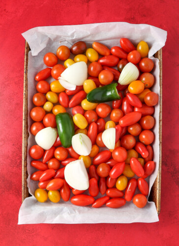 pan of cherry tomatoes, onions, jalapeno ready to roast.