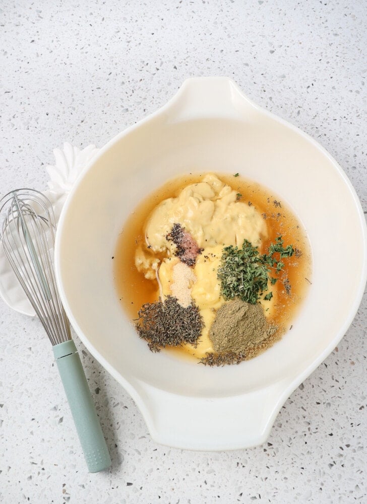 Seasonings in a bowl to make chicken and dumplings including poultry seasoning cream chicken thyme parsley salt and pepper and broth